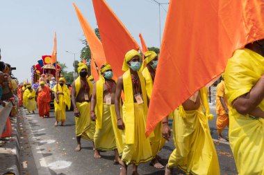 Haridwar, Uttarakhand, Hindistan - 16 Nisan 2021: Maha Kumbhmela etkinliği. Sadhus, parlak safran bayraklarıyla sarı elbiseli sanyasiler kutsal Ganj nehrinde shahi snaan yemek için yürüyorlar..