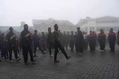 Darjeeling, Batı Bengal, Hindistan -11.08.2023: Bağımsızlık Günü hazırlığı 15 Ağustos 2023. Askeri eğitim için Darjeeling Alışveriş Merkezi 'nin önünden geçen öğrenciler. Sisli bir sabah.