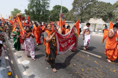 Haridwar, Uttarakhand, Hindistan - 16 Nisan 2021: Hindu kadınlar Ganj Nehri 'nde shahi snaan yemek için geçit töreninde ellerinde bayraklar tutan maskeli kadınlar. Kutsal Maha Kumbhmela etkinliği.