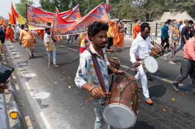 Haridwar, Uttarakhand, Hindistan - 16 Nisan 2021: Maha Kumbhmela etkinliği. Sadhus, safran elbiseli Sanyasis müzisyenlerle yolda yürüyor ve Ganj nehrinde shahi snaan yemeye gidiyor..