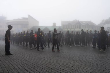Darjeeling, Batı Bengal, Hindistan -11.08.2023: Bağımsızlık Günü hazırlığı 15 Ağustos 2023. Askeri eğitim için Darjeeling Alışveriş Merkezi 'nin önünden geçen öğrenciler. Sisli bir sabah.