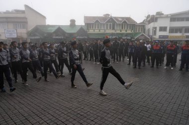 Darjeeling, Batı Bengal, Hindistan-11.08.2023: Sisli sabahta askeri eğitim. 15 Ağustos 2023 'teki Bağımsızlık Günü kutlamaları için Darjeeling Alışveriş Merkezi' nin önünden geçen öğrenciler.,