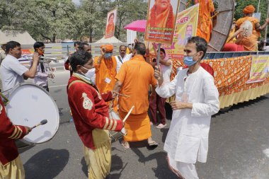 Haridwar, Uttarakhand, Hindistan - 16 Nisan 2021: Maha Kumbhmela etkinliği. Parlak elbiseli Hindu fanatikler Ganj Nehri 'nde Shahi snaan yemek için neşe içinde dans ediyorlar. Müzik çalan grup partisi.