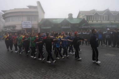 Darjeeling, Batı Bengal, Hindistan -11.08.2023: Sisli sabahta kız öğrenci askeri eğitimi, Bağımsızlık Günü kutlamaları için Darjeeling Alışveriş Merkezi 'nde yürüyen öğrenciler.