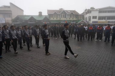 Darjeeling, Batı Bengal, Hindistan -11.08.2023: Bağımsızlık Günü hazırlığı 15 Ağustos 2023. Askeri eğitim için Darjeeling Alışveriş Merkezi 'nin önünden geçen öğrenciler. Sisli bir sabah.