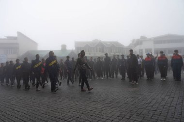 Darjeeling, Batı Bengal, Hindistan -11.08.2023: Bağımsızlık Günü hazırlığı 15 Ağustos 2023. Askeri eğitim için Darjeeling Alışveriş Merkezi 'nin önünden geçen öğrenciler. Sisli bir sabah.