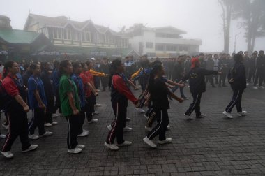 Darjeeling, Batı Bengal, Hindistan-11.08.2023: Sisli sabahlarda kız askeri eğitim. 15 Ağustos 'ta Bağımsızlık Günü kutlamalarına hazırlanmak üzere Darjeeling Alışveriş Merkezi' nde geçen okul öğrencileri.