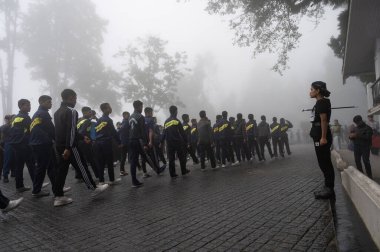 Darjeeling, Batı Bengal, Hindistan -11.08.2023: 15 Ağustos 2023 'te Bağımsızlık Günü kutlamaları için Darjeeling Alışveriş Merkezi' nde yürüyüş yapan öğrenciler, askeri eğitim. Sisli bir sabah.