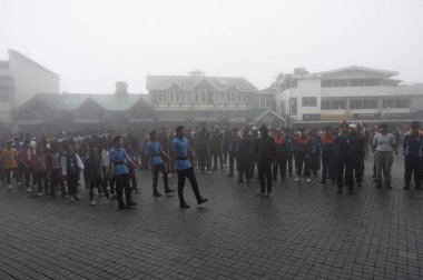 Darjeeling, Batı Bengal, Hindistan -11.08.2023: Bağımsızlık Günü hazırlığı 15 Ağustos 2023. Askeri eğitim için Darjeeling Alışveriş Merkezi 'nin önünden geçen öğrenciler. Sisli bir sabah.