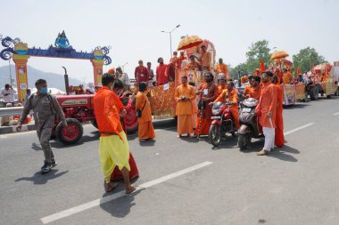 Haridwar, Uttarakhand, Hindistan - 16 Nisan 2021: Grup fotoğrafı çekiliyor. Hindu keşişler, sadhular, parlak safran elbiseli sanyasiler bisiklete binip Ganj Nehri 'ndeki Shahi Snaan' a gidiyorlar..
