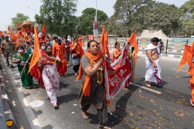 Haridwar, Uttarakhand, Hindistan - 16 Nisan 2021: Hindu kadınlar Ganj Nehri 'nde shahi snaan yemek için geçit töreninde ellerinde bayraklar tutan maskeli kadınlar. Kutsal Maha Kumbhmela etkinliği.