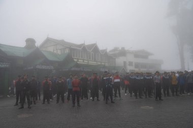 Darjeeling, Batı Bengal, Hindistan -11.08.2023: 15 Ağustos 2023 'te Bağımsızlık Günü kutlamaları için Darjeeling Alışveriş Merkezi' nde yürüyüş yapan öğrenciler, askeri eğitim. Sisli bir sabah.