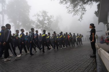Darjeeling, Batı Bengal, Hindistan-11.08.2023: Sisli sabahta askeri eğitim. 15 Ağustos 2023 'teki Bağımsızlık Günü kutlamaları için Darjeeling Alışveriş Merkezi' nin önünden geçen öğrenciler.,