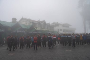 Darjeeling, Batı Bengal, Hindistan -11.08.2023: Bağımsızlık Günü hazırlığı 15 Ağustos 2023. Askeri eğitim için Darjeeling Alışveriş Merkezi 'nin önünden geçen öğrenciler. Sisli bir sabah.