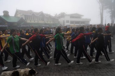 Darjeeling, Batı Bengal, Hindistan-11.08.2023: Sisli sabahlarda kız askeri eğitim. 15 Ağustos 'ta Bağımsızlık Günü kutlamalarına hazırlanmak üzere Darjeeling Alışveriş Merkezi' nde geçen okul öğrencileri.