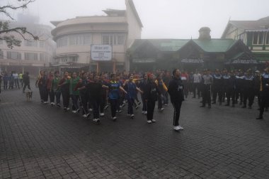 Darjeeling, Batı Bengal, Hindistan-11.08.2023: Sisli sabahlarda kız askeri eğitim. 15 Ağustos 'ta Bağımsızlık Günü kutlamalarına hazırlanmak üzere Darjeeling Alışveriş Merkezi' nde geçen okul öğrencileri.