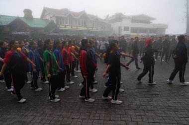 Darjeeling, Batı Bengal, Hindistan -11.08.2023: Sisli sabahta kız öğrenci askeri eğitimi, Bağımsızlık Günü kutlamaları için Darjeeling Alışveriş Merkezi 'nde yürüyen öğrenciler.
