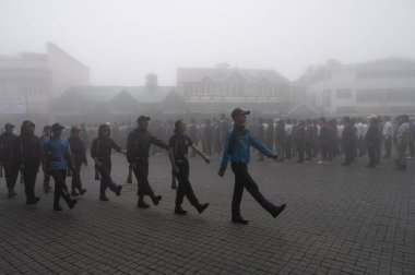 Darjeeling, Batı Bengal, Hindistan -11.08.2023: 15 Ağustos 2023 'te Bağımsızlık Günü kutlamaları için Darjeeling Alışveriş Merkezi' nde yürüyüş yapan öğrenciler, askeri eğitim. Sisli bir sabah.