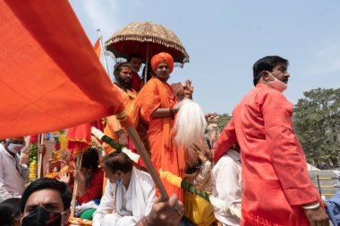 Haridwar, Uttarakhand, Hindistan - 16 Nisan 2021: Hindu rahipler, sadhus, safran elbiseli sanyasiler, Ganj Nehri 'ndeki Shahi Snaan için traktörler giyiyorlar. Maha Kumbhmela etkinliği, Hinduizm, Hindistan.