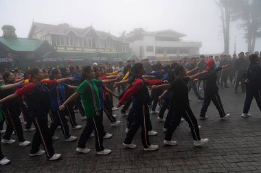 Darjeeling, Batı Bengal, Hindistan -11.08.2023: Sisli sabahta kız öğrenci askeri eğitimi, Bağımsızlık Günü kutlamaları için Darjeeling Alışveriş Merkezi 'nde yürüyen öğrenciler.