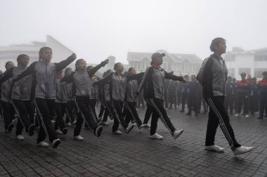 Darjeeling, Batı Bengal, Hindistan -11.08.2023: 15 Ağustos 2023 'te Bağımsızlık Günü kutlamaları için Darjeeling Alışveriş Merkezi' nde yürüyüş yapan öğrenciler, askeri eğitim. Sisli bir sabah.
