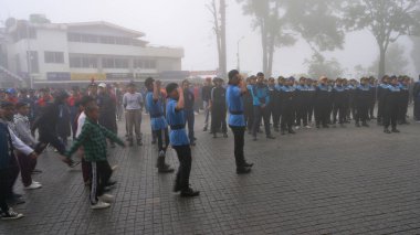 Darjeeling, Batı Bengal, Hindistan -11.08.2023: 15 Ağustos 2023 'te Bağımsızlık Günü kutlamaları için Darjeeling Alışveriş Merkezi' nde yürüyüş yapan öğrenciler, askeri eğitim. Sisli bir sabah.