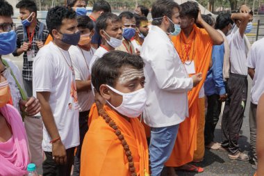 Haridwar, Uttarakhand, Hindistan - 16 Nisan 2021: Maha Kumbhmela etkinliği. Parlak elbiseli Hindu fanatikler kutsal Ganj nehrinde shahi snaan yemek için yürüyüş yapıyorlar. Hindu etkinliği.