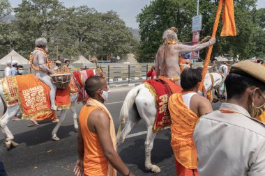 Haridwar, Uttarakhand, Hindistan - 16 Nisan 2021: Hindu çıplak sadhu, naga baba, naga sanyasi Ganj nehrinde shahi snaan yediği ve Har Har Mahadev diye bağırdığı için at sürüyor. Kumbhmela olayı.