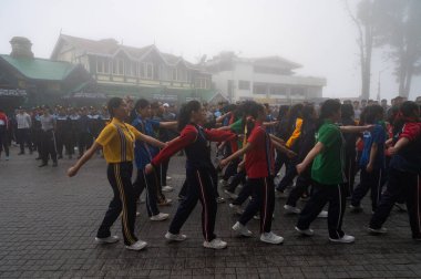 Darjeeling, Batı Bengal, Hindistan -11.08.2023: Sisli sabahta kız öğrenci askeri eğitimi, Bağımsızlık Günü kutlamaları için Darjeeling Alışveriş Merkezi 'nde yürüyen öğrenciler.