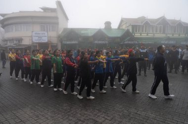 Darjeeling, Batı Bengal, Hindistan -11.08.2023: Sisli sabahta kız öğrenci askeri eğitimi, Bağımsızlık Günü kutlamaları için Darjeeling Alışveriş Merkezi 'nde yürüyen öğrenciler.