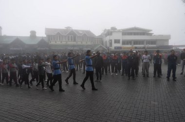 Darjeeling, Batı Bengal, Hindistan -11.08.2023: 15 Ağustos 2023 'te Bağımsızlık Günü kutlamaları için Darjeeling Alışveriş Merkezi' nde yürüyüş yapan öğrenciler, askeri eğitim. Sisli bir sabah.