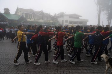 Darjeeling, Batı Bengal, Hindistan -11.08.2023: Sisli sabahta kız öğrenci askeri eğitimi, Bağımsızlık Günü kutlamaları için Darjeeling Alışveriş Merkezi 'nde yürüyen öğrenciler.