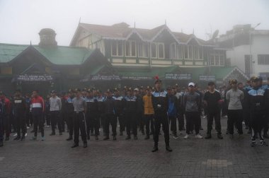 Darjeeling, Batı Bengal, Hindistan -11.08.2023: 15 Ağustos 2023 'te Bağımsızlık Günü kutlamaları için Darjeeling Alışveriş Merkezi' nde yürüyüş yapan öğrenciler, askeri eğitim. Sisli bir sabah.