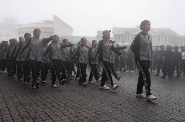 Darjeeling, Batı Bengal, Hindistan -11.08.2023: 15 Ağustos 2023 'te Bağımsızlık Günü kutlamaları için Darjeeling Alışveriş Merkezi' nde yürüyüş yapan öğrenciler, askeri eğitim. Sisli bir sabah.