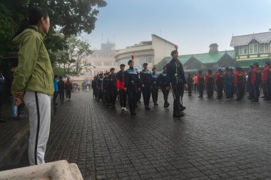 Darjeeling, Batı Bengal, Hindistan -11.08.2023: Bağımsızlık Günü hazırlığı 15 Ağustos 2023. Askeri eğitim için Darjeeling Alışveriş Merkezi 'nin önünden geçen öğrenciler. Sisli bir sabah.