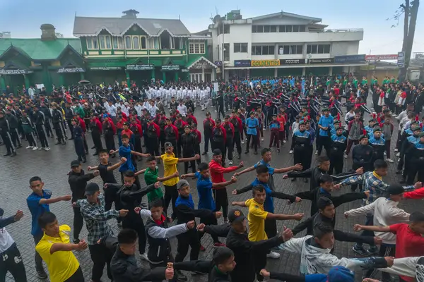 Darjeeling, Batı Bengal, Hindistan -11.08.2023: Bağımsızlık Günü hazırlığı 15 Ağustos 2023. Askeri eğitim için Darjeeling Alışveriş Merkezi 'nin önünden geçen öğrenciler. Sisli bir sabah.
