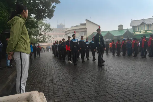 Darjeeling, Batı Bengal, Hindistan -11.08.2023: Bağımsızlık Günü hazırlığı 15 Ağustos 2023. Askeri eğitim için Darjeeling Alışveriş Merkezi 'nin önünden geçen öğrenciler. Sisli bir sabah.