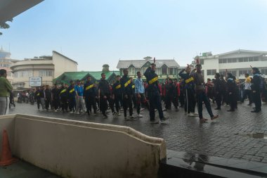 Darjeeling, Batı Bengal, Hindistan -11.08.2023: 15 Ağustos 2023 'te Bağımsızlık Günü kutlamaları için Darjeeling Alışveriş Merkezi' nde yürüyüş yapan öğrenciler, askeri eğitim. Sisli bir sabah.