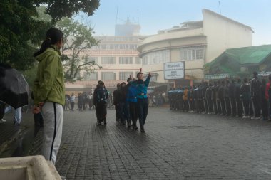 Darjeeling, Batı Bengal, Hindistan -11.08.2023: 15 Ağustos 2023 'te Bağımsızlık Günü kutlamaları için Darjeeling Alışveriş Merkezi' nde yürüyüş yapan öğrenciler, askeri eğitim. Sisli bir sabah.