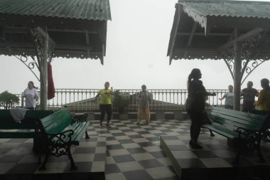 Darjeeling, Batı Bengal, Hindistan - 11.08.2023: Spor yapan genç kadınlar, Darjeeling alışveriş merkezinde sisli bir sabah geçirerek, sağlık bilincine sahip kadınların grup egzersizlerinin faydalarını gösteriyorlar. Genç Himalaya yaşam tarzı.