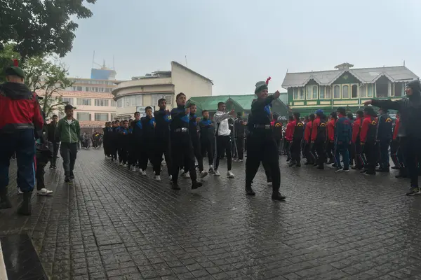 Darjeeling, Batı Bengal, Hindistan -11.08.2023: Bağımsızlık Günü hazırlığı 15 Ağustos 2023. Askeri eğitim için Darjeeling Alışveriş Merkezi 'nin önünden geçen öğrenciler. Sisli bir sabah.