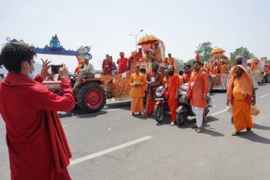 Haridwar, Uttarakhand, Hindistan - 16 Nisan 2021: Grup fotoğrafı çekiliyor. Hindu keşişler, sadhular, parlak safran elbiseli sanyasiler bisiklete binip Ganj Nehri 'ndeki Shahi Snaan' a gidiyorlar..