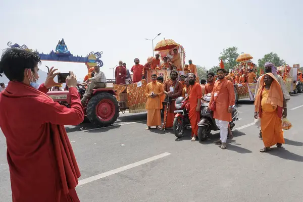Haridwar, Uttarakhand, Hindistan - 16 Nisan 2021: Grup fotoğrafı çekiliyor. Hindu keşişler, sadhular, parlak safran elbiseli sanyasiler bisiklete binip Ganj Nehri 'ndeki Shahi Snaan' a gidiyorlar..