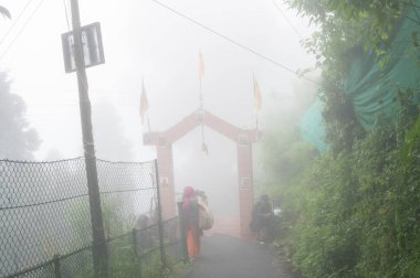 Darjeeling, Batı Bengal, Hindistan-11.08.2023: Mahakal Tapınağı veya Mahakal Mandir 'deki Hindu tapınağı, Shiva ve Lord Buddhha' ya adanmıştır. Muson sisiyle kaplı yemyeşil bir yol..