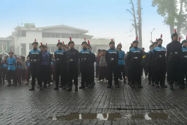 Darjeeling, Batı Bengal, Hindistan -11.08.2023: Bağımsızlık Günü hazırlığı 15 Ağustos 2023. Askeri eğitim için Darjeeling Alışveriş Merkezi 'nin önünden geçen öğrenciler. Sisli bir sabah.