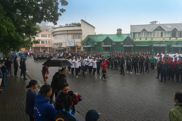 Darjeeling, Batı Bengal, Hindistan -11.08.2023: Bağımsızlık Günü hazırlığı 15 Ağustos 2023. Askeri eğitim için Darjeeling Alışveriş Merkezi 'nin önünden geçen öğrenciler. Sisli bir sabah.