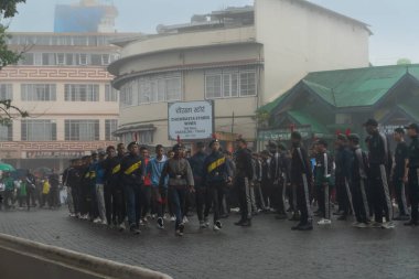 Darjeeling, Batı Bengal, Hindistan -11.08.2023: 15 Ağustos 2023 'te Bağımsızlık Günü kutlamaları için Darjeeling Alışveriş Merkezi' nde yürüyüş yapan öğrenciler, askeri eğitim. Sisli bir sabah.
