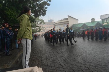 Darjeeling, Batı Bengal, Hindistan -11.08.2023: Bağımsızlık Günü hazırlığı 15 Ağustos 2023. Askeri eğitim için Darjeeling Alışveriş Merkezi 'nin önünden geçen öğrenciler. Sisli bir sabah.