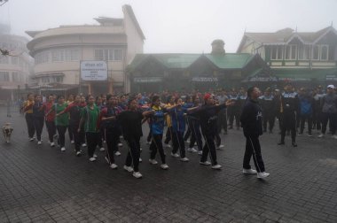 Darjeeling, Batı Bengal, Hindistan-11.08.2023: Sisli sabahlarda kız askeri eğitim. 15 Ağustos 'ta Bağımsızlık Günü kutlamalarına hazırlanmak üzere Darjeeling Alışveriş Merkezi' nde geçen okul öğrencileri.