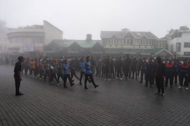 Darjeeling, Batı Bengal, Hindistan -11.08.2023: Bağımsızlık Günü hazırlığı 15 Ağustos 2023. Askeri eğitim için Darjeeling Alışveriş Merkezi 'nin önünden geçen öğrenciler. Sisli bir sabah.